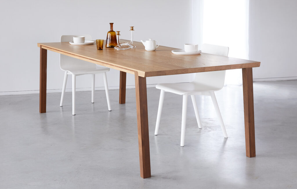 Moderne eettafel waarbij de poten doorlopen in het blad.